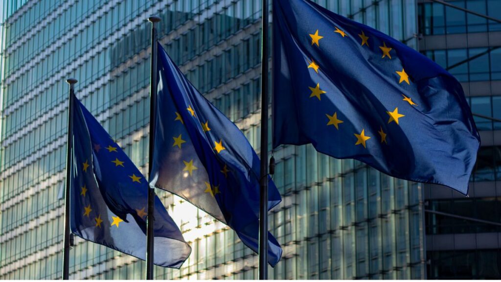 L'UE rafforza il Partenariato UE SST con quattro nuovi membri e consolida la cooperazione sulla sorveglianza spaziale 1 Bandiere dell'Unione europea davanti a un edificio istituzionale, simbolo della cooperazione rafforzata nel Partenariato UE SST per la sorveglianza spaziale.