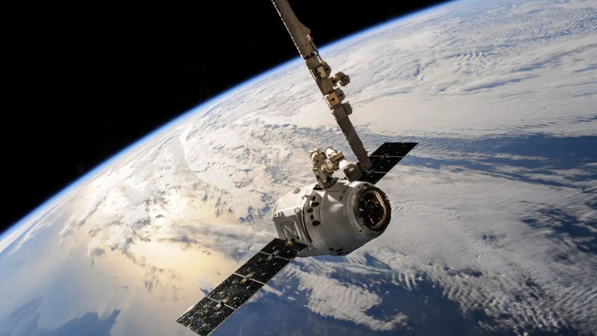 Veicolo spaziale in orbita terrestre con la Terra sullo sfondo, immagine a corredo del rapporto del National Space Operations Centre sui rischi nel dominio spaziale.