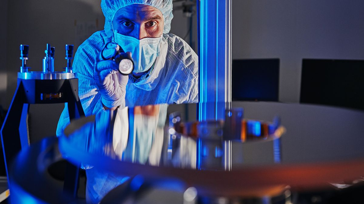 Tecnico di Officina Stellare ispeziona un componente di ottiche spaziali destinato a programmi di osservazione della Terra.