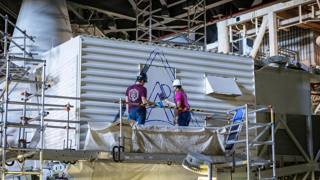 NASA investe 10,5 milioni di dollari nei tecnici per l’industria spaziale americana 1 Tecnici per l’industria aerospaziale dipingono il logo Artemis sulla White Room della NASA