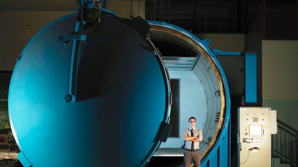 Bercella: “I data center orbitali diventeranno realtà nei prossimi dieci anni” 1 Grande impianto industriale cilindrico blu con portello aperto e una persona davanti.