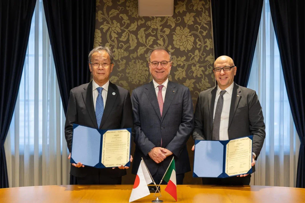 Italia e Giappone firmano una dichiarazione di intenti per un partenariato strategico sullo spazio 1 Tre rappresentanti istituzionali durante una cerimonia, con due documenti esposti e le bandiere di Italia e Giappone in primo piano.