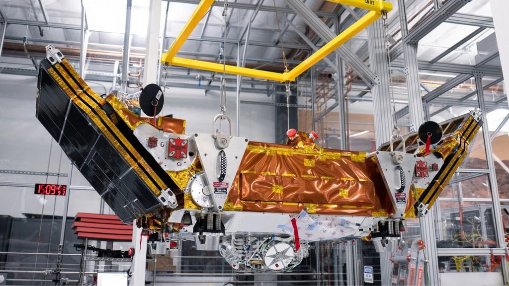 Impulse Space, Mira pronta per Falcon 9 dopo 10 mesi di preparazione 1 Veicolo spaziale Mira di Impulse Space per LEO Express 4, sospeso in una struttura industriale con pannelli solari dispiegati