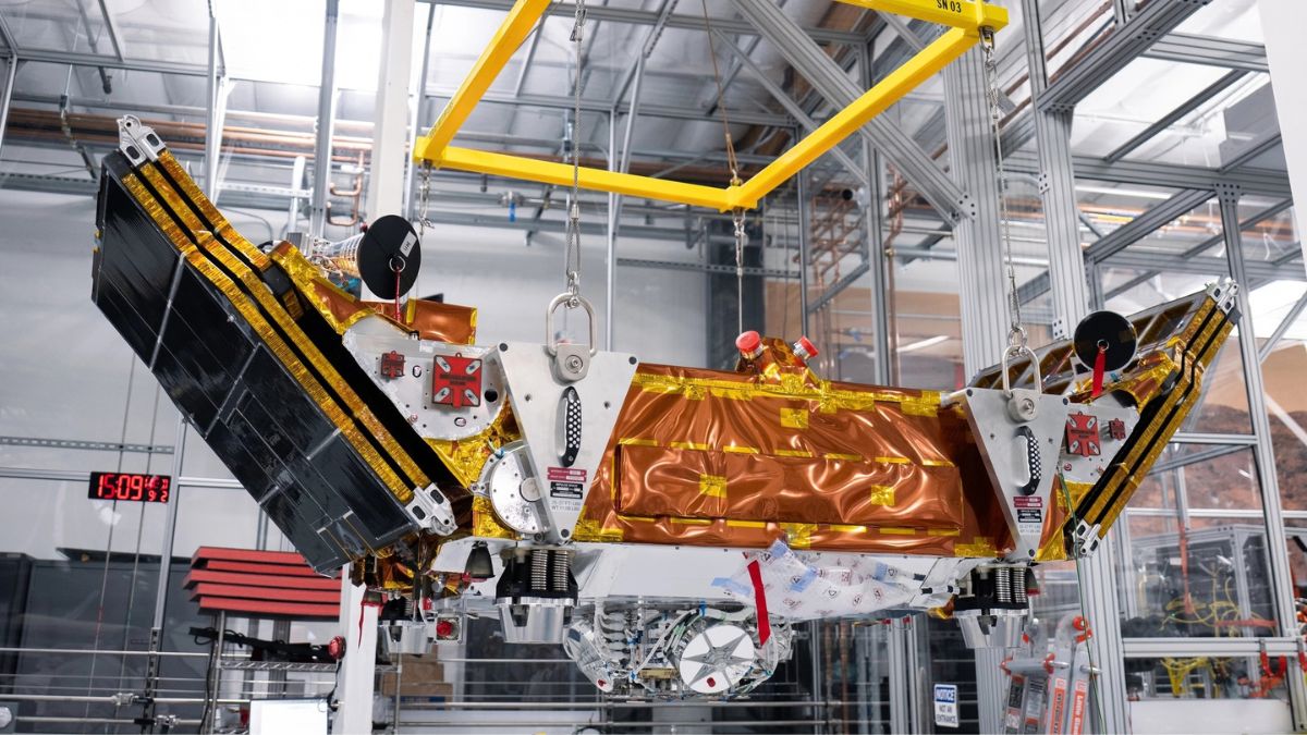 Veicolo spaziale Mira di Impulse Space per LEO Express 4, sospeso in una struttura industriale con pannelli solari dispiegati