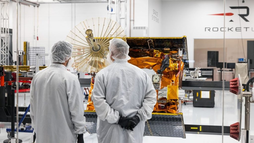 Rocket Lab porta in orbita Maxwell: Viasat testerà le comunicazioni per la NASA 1 Due tecnici di Rocket Lab davanti al satellite Maxwell di Viasat durante le attività di integrazione in camera bianca.