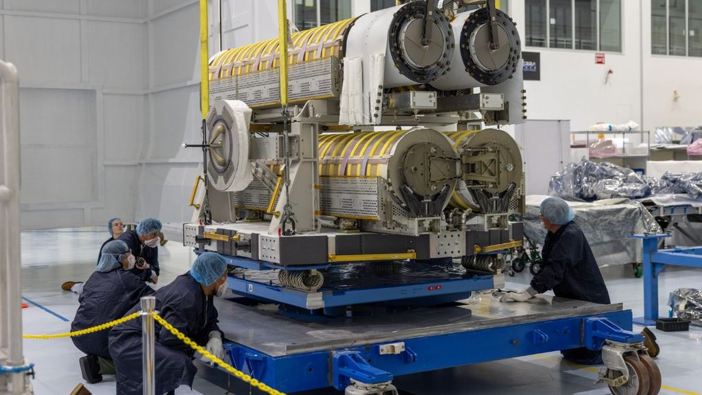 NASA, due passeggiate spaziali per portare la potenza della ISS a 215 kW 1 Pannelli solari IROSA ripiegati in uno stabilimento con personale tecnico al lavoro